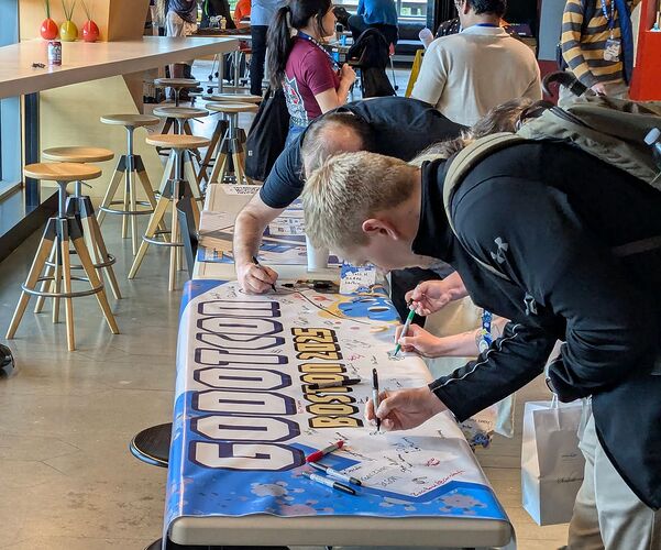 The GodotCon Boston 2025 banner being signed by attendees on the third and last day of the convention.