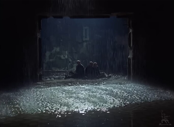 The Stalker, the Professor, and the Writer all sitting on the floor in front of an archway. The room between them and the camera is filled with water and it is raining.